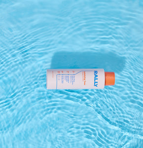 Rally toner bottle floating in water on blue background